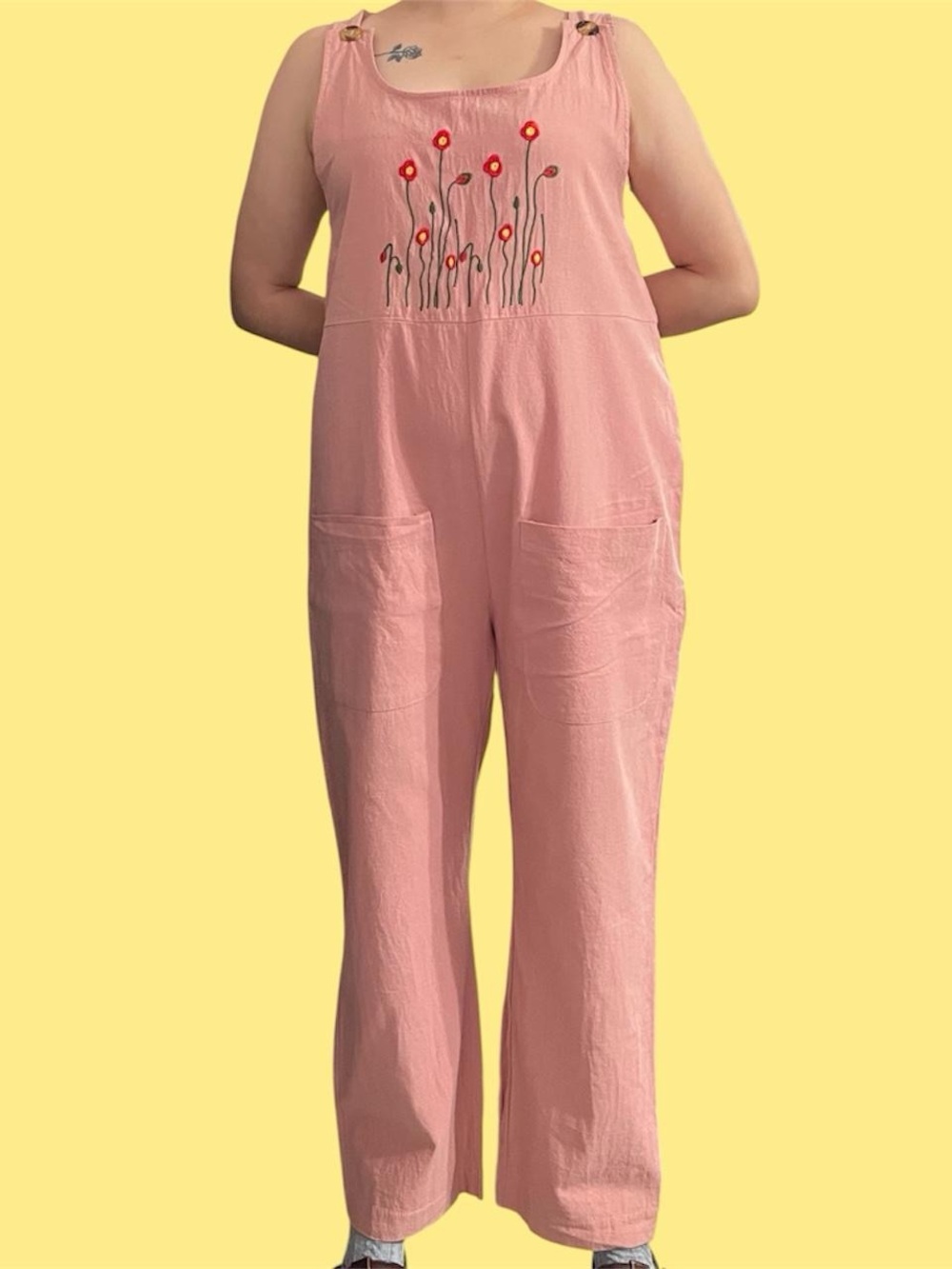 Pink overalls with floral embroidery.
